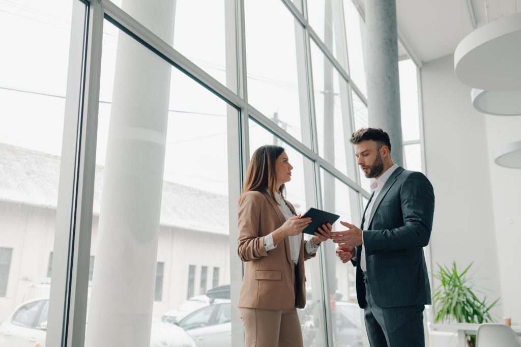 Business colleagues using digital tablet and discussing business strategy